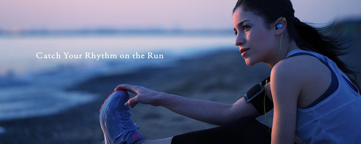 photo of woman with yamaha earbuds in a beach with the word catch your rhythm on the run.